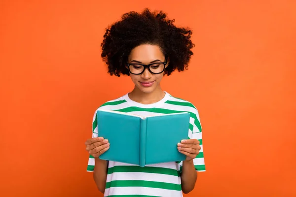 Portrait of attractive focused intellectual wavy-haired girl reading diary to do list plan isolated over bright orange color background — Foto Stock