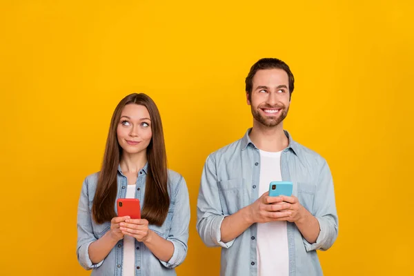 Photo de cuning millennial couple de cheveux bruns avec téléphone look promo porter chemise jeans isolé sur fond jaune — Photo