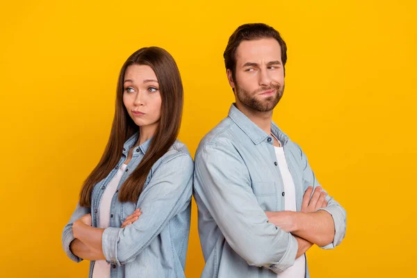 Photo of unhappy upset husband wife wear jeans shirts having quarrel arms folded isolated yellow color background — Stock Fotó