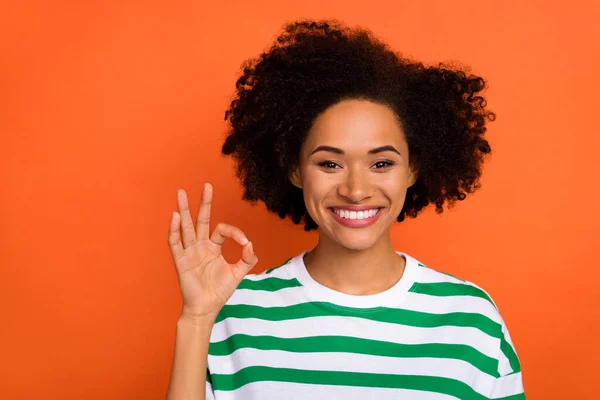 Porträtt av attraktiv glad glad glad vågigt hår flicka visar ok-tecken isolerad över pulserande orange färg bakgrund — Stockfoto