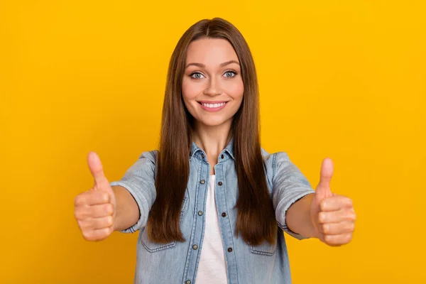 Фото смішної впевненої молодої леді в джинсовій сорочці, що показує два великі пальці вгору ізольований жовтий кольоровий фон — стокове фото