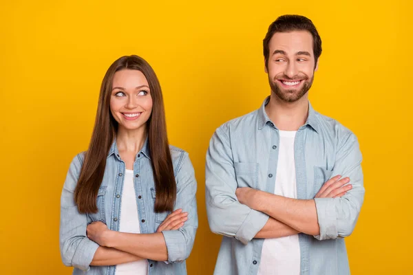 Photo of positive tricky sister brother dressed denim shirts arms crossed looking each other isolated yellow color background — Foto Stock