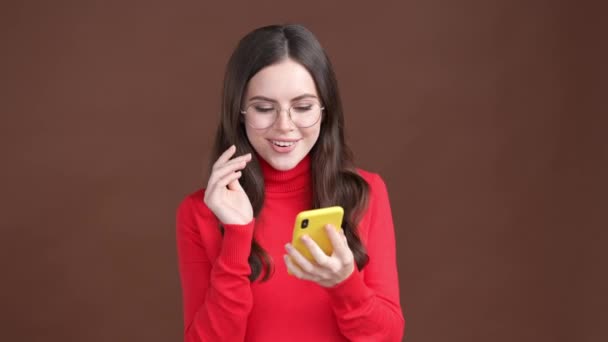 Positiv dame bruger app gadget chat isoleret brun farve baggrund – Stock-video