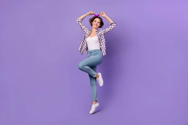 Photo of charming shiny lady dressed checkered shirt jumping high isolated purple color background — Stok fotoğraf