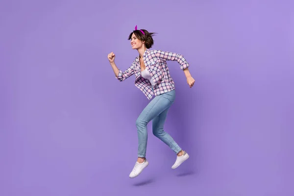 魅力的な急いで女性の服を着たチェックシャツジャンプ高実行中の高速孤立紫色の背景 — ストック写真