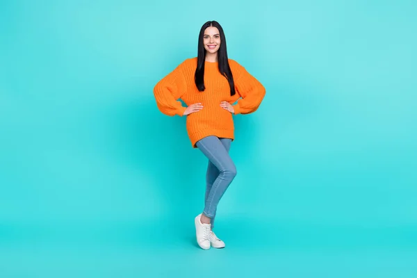 Photo of shiny pretty lady dressed knitted pullover smiling arms waist isolated teal color background — ストック写真