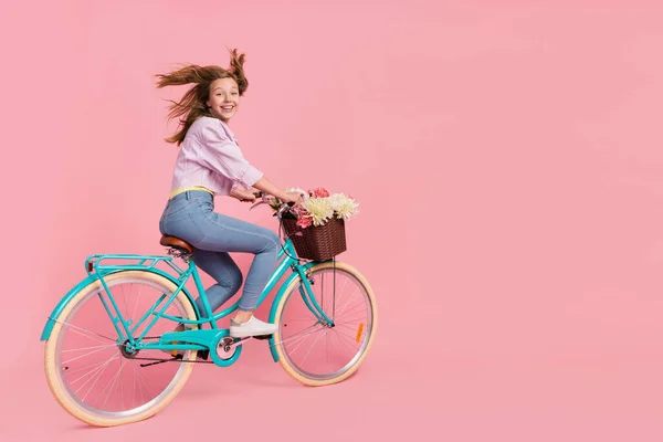 Foto do correio funky senhora pessoa dirigir bicicleta vento sopro cabelo desgaste roupa casual isolado cor rosa fundo — Fotografia de Stock