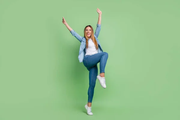 Full body photo of young lady yell wear shirt jeans sneakers isolated on green background — Stock Fotó