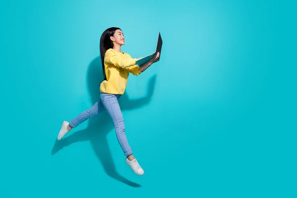 Full length photo of pretty funny lady dressed yellow sweater jumping chatting gadget empty space isolated turquoise color background — Foto Stock