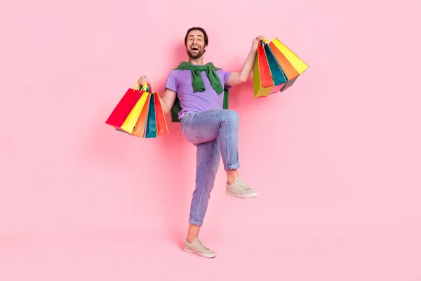 Full body photo of ecstatic overjoyed male have fun go shopping visit mall center isolated on pink color background — стоковое фото