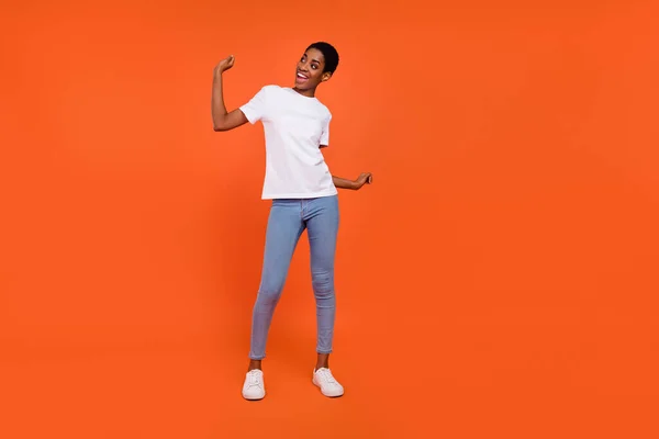 Plná délka fotografie androgyne dáma ruce nahoru tanec energické oblečení trendy tričko džíny izolované lesk barva pozadí — Stock fotografie