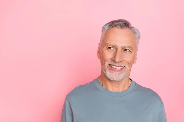 Photo of confident dreamy man pensioner dressed grey shirt looking empty space isolated pink color background — ストック写真