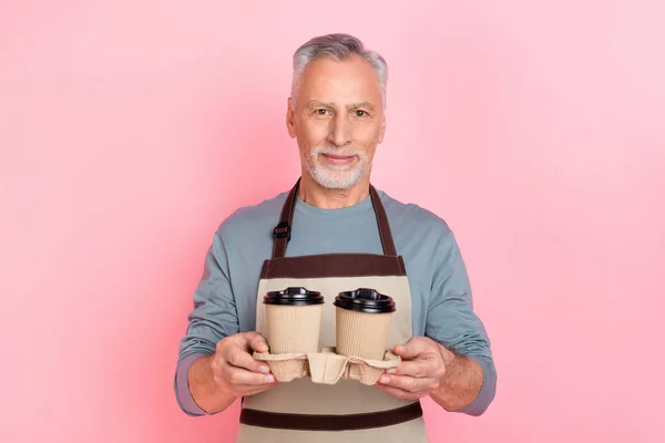 Photo of cute charming retired man wear grey shirt apron preparing coffee take out isolated pink color background —  Fotos de Stock