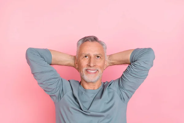 Photo of dreamy cute man pensioner dressed grey shirt looking up empty space arms behind head isolated pink color background — ストック写真