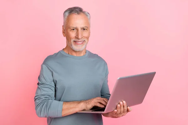 Photo of sweet pretty retired man wear grey shirt reading modern gadget empty space isolated pink color background — Stockfoto