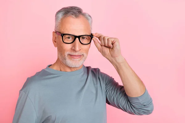 Foto de divertido hombre confiado pensionista vestido gris camisa brazo gafas vacío espacio aislado color rosa fondo — Foto de Stock