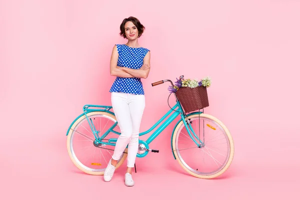Full body photo of boss young lady ride bicycle crossed arms wear blouse pants sneakers isolated on pink background — Stockfoto