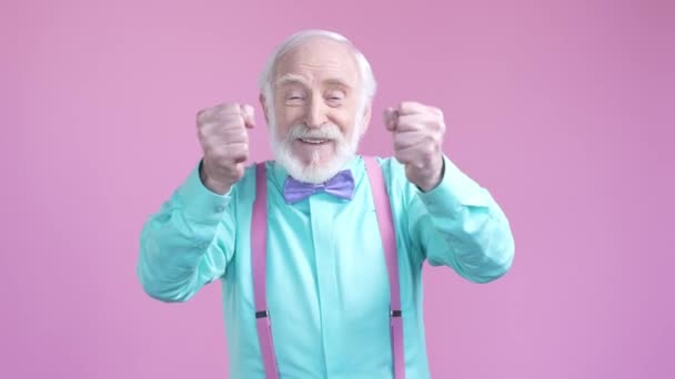 Aged man celebrate soccer win fist up isolated pastel color background — ストック動画