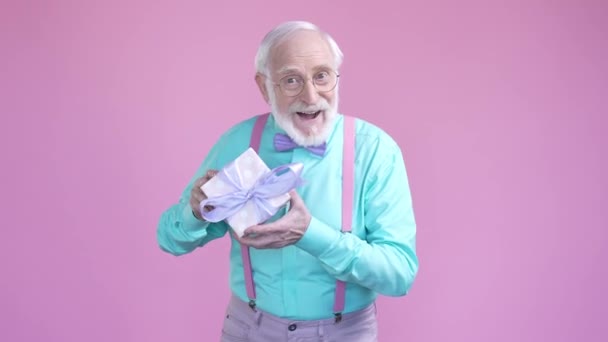 Aged man give woman day package isolated pastel color background — стоковое видео