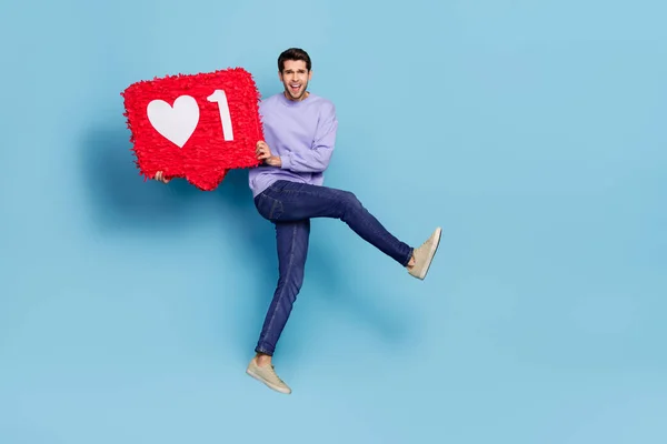 Full length body size view of attractive cheery guy jumping holding like board chat app isolated over bright blue color background — Foto de Stock