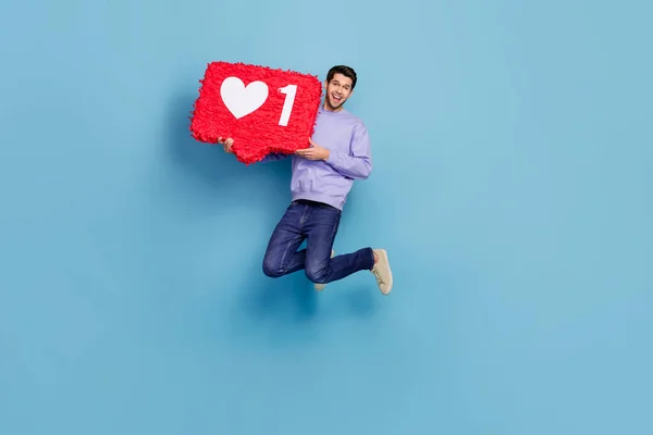 Full length body size view of attractive cheerful guy jumping holding red like board isolated over bright blue color background — Foto de Stock