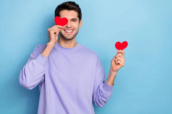 Photo of funky young brunet guy hold hearts wear sweater isolated on blue color background — Stock fotografie