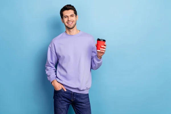 Photo of nice millennial brunet guy drink latte wear pullover isolated on blue color background — Stockfoto