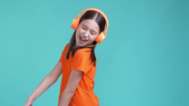 Ενέργεια χορός σχολιαρόπαιδο ακούσει ροκ μουσική ακουστικά απομονωμένο φόντο κυανό χρώμα — Αρχείο Βίντεο