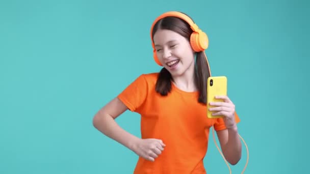 Funky crazy schoolkid listen headset gadget pop isolated cyan color background — Stockvideo