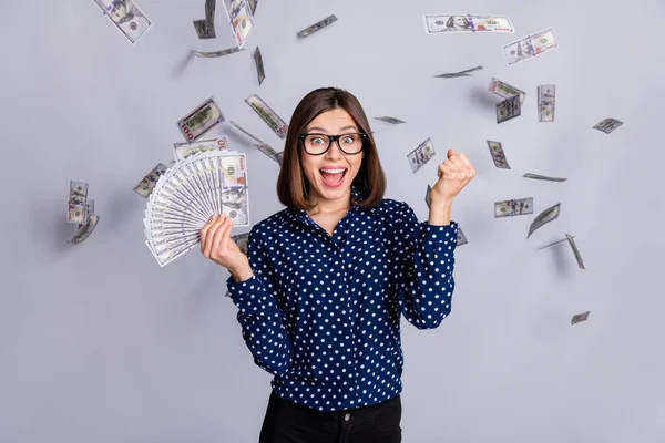 Portrait of astonished lady raise fist hold cash income salary lucky isolated on grey color background — 스톡 사진