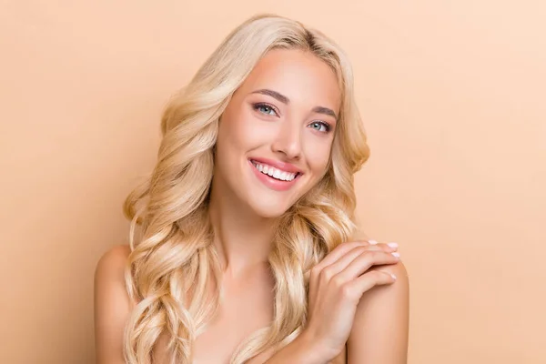 Portrait of attractive healthy cheerful wavy-haired girl touching shoulder scrub exfoliation isolated over beige pastel color background — Stockfoto