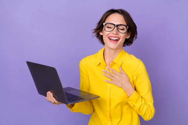 Photo of funny millennial lady hold laptop hand chest wear yellow outfit eyewear isolated on violet color background — Zdjęcie stockowe