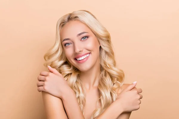 Retrato de atractiva chica de pelo ondulado alegre tocando hombros lisos ducha fresca aislada sobre fondo de color pastel beige —  Fotos de Stock