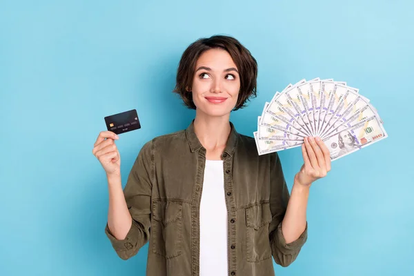 Photo of sweet millennial short hairstyle lady hold money card look promo wear khaki shirt isolated on blue color background — Stockfoto