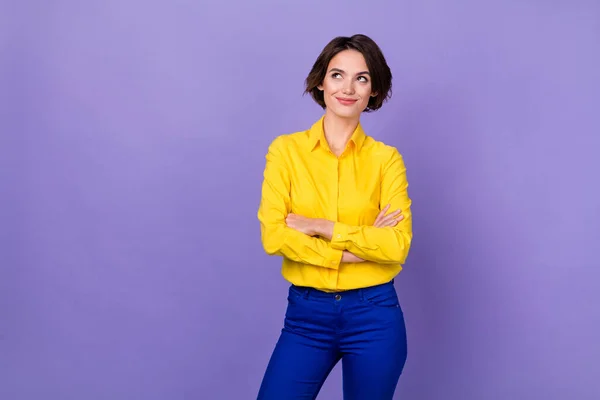 Photo of cute young lady crossed palms look up wear yellow shirt pants isolated on violet color background — Stock Photo, Image