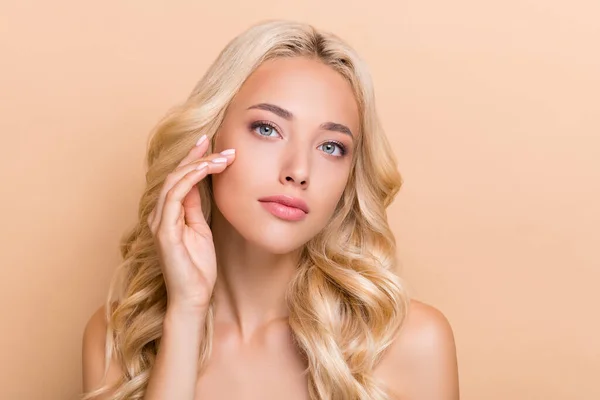 Portrait of attractive confident groomed wavy-haired girl touching soft skin anti acne pore isolated over beige pastel color background — Zdjęcie stockowe