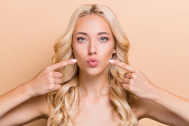 Portrait of attractive wavy-haired girl demonstrating perfect lips shape contour isolated over beige pastel color background clipart