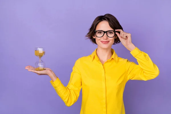 Photo of nice hr millennial lady hold clock wear yellow outfit eyewear isolated on violet color background — 스톡 사진