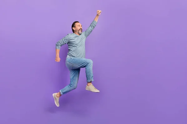 Full size profile side photo of mature man fly strength help jumper look empty space isolated over purple color background — Zdjęcie stockowe