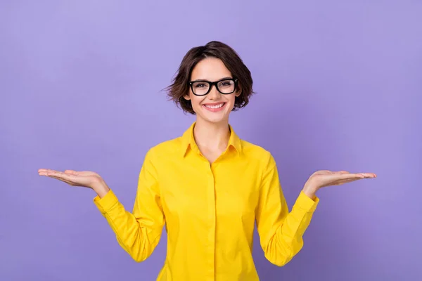 Фотографія молодої брюнетки леді тримає порожній простір одягу жовта блузка ізольована на фіолетовому кольоровому фоні — стокове фото