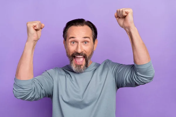 Portrait de bel homme d'âge moyen lever les poings dans la victoire gagner de l'argent de loterie isolé sur fond de couleur violette — Photo