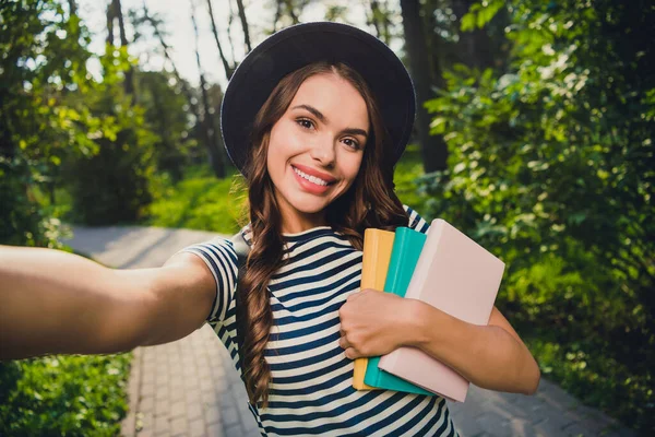 Self-portrait of attractive cheerful smart girl resting pastime holding academic book on fresh air outdoors — Fotografia de Stock
