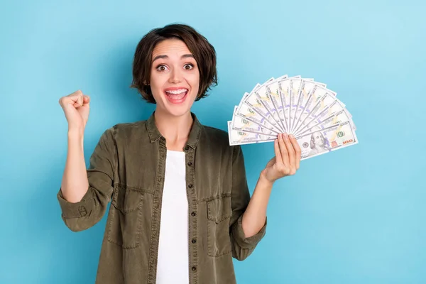 Photo of funny millennial short hairstyle lady hold money yell wear khaki shirt isolated on blue color background — Fotografia de Stock