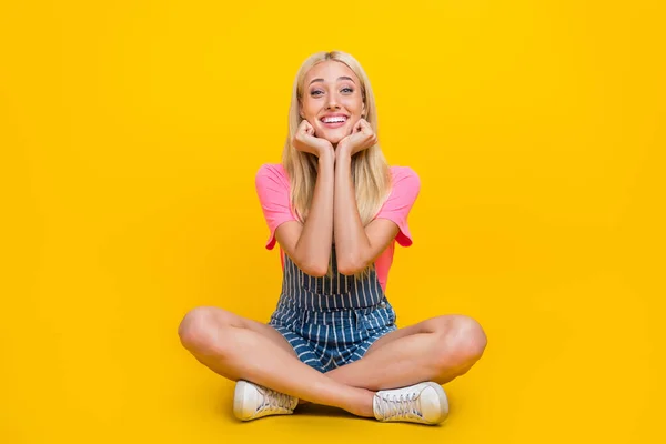Full length photo of satisfied friendly girl arms cheeks beaming smile isolated on yellow color background — ストック写真