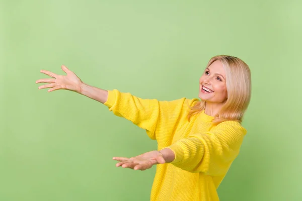 Photo of excited aged lady try catch advert bargain fall down empty space isolated on green color background — Stok fotoğraf