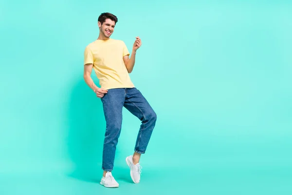 Full size photo of funny brunet guy dance wear t-shirt jeans sneakers isolated on turquoise background — Stockfoto