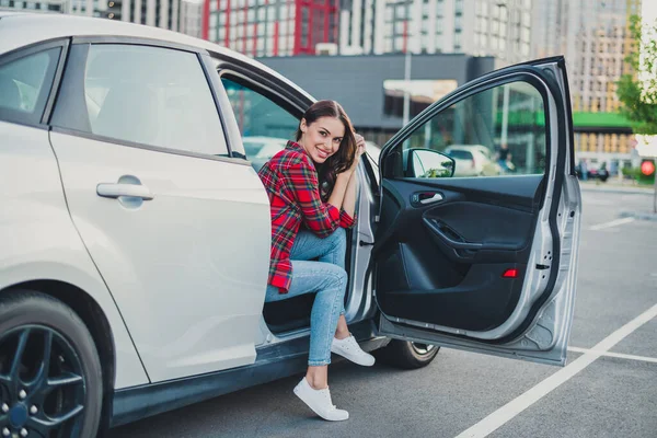 Portrett av en munter, glad passasjer som sitter i bil og tilbringer fritidsferie på parkeringsplassen utendørs – stockfoto