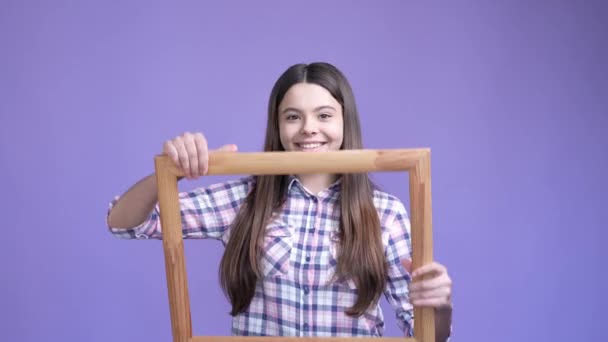 Aufgeregt Teenager Mädchen halten Holz Grenze Schnappschuss isoliert helle Farbe Hintergrund — Stockvideo