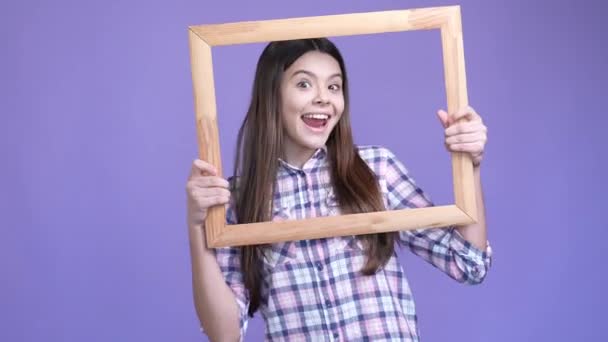 Kleines Kind halten Holzrahmen machen verspielt Gesicht isoliert Glanz Farbe Hintergrund — Stockvideo