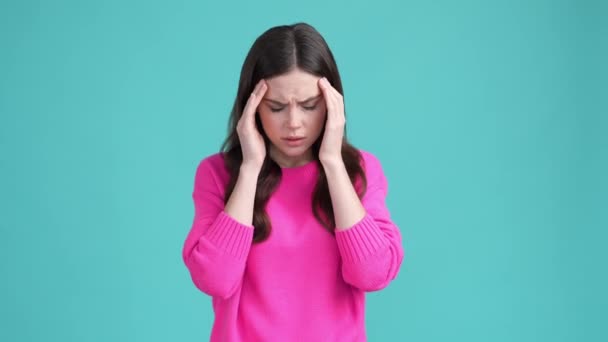 Lady rubbing forehead suffer head ache isolated cyan color background — Video Stock